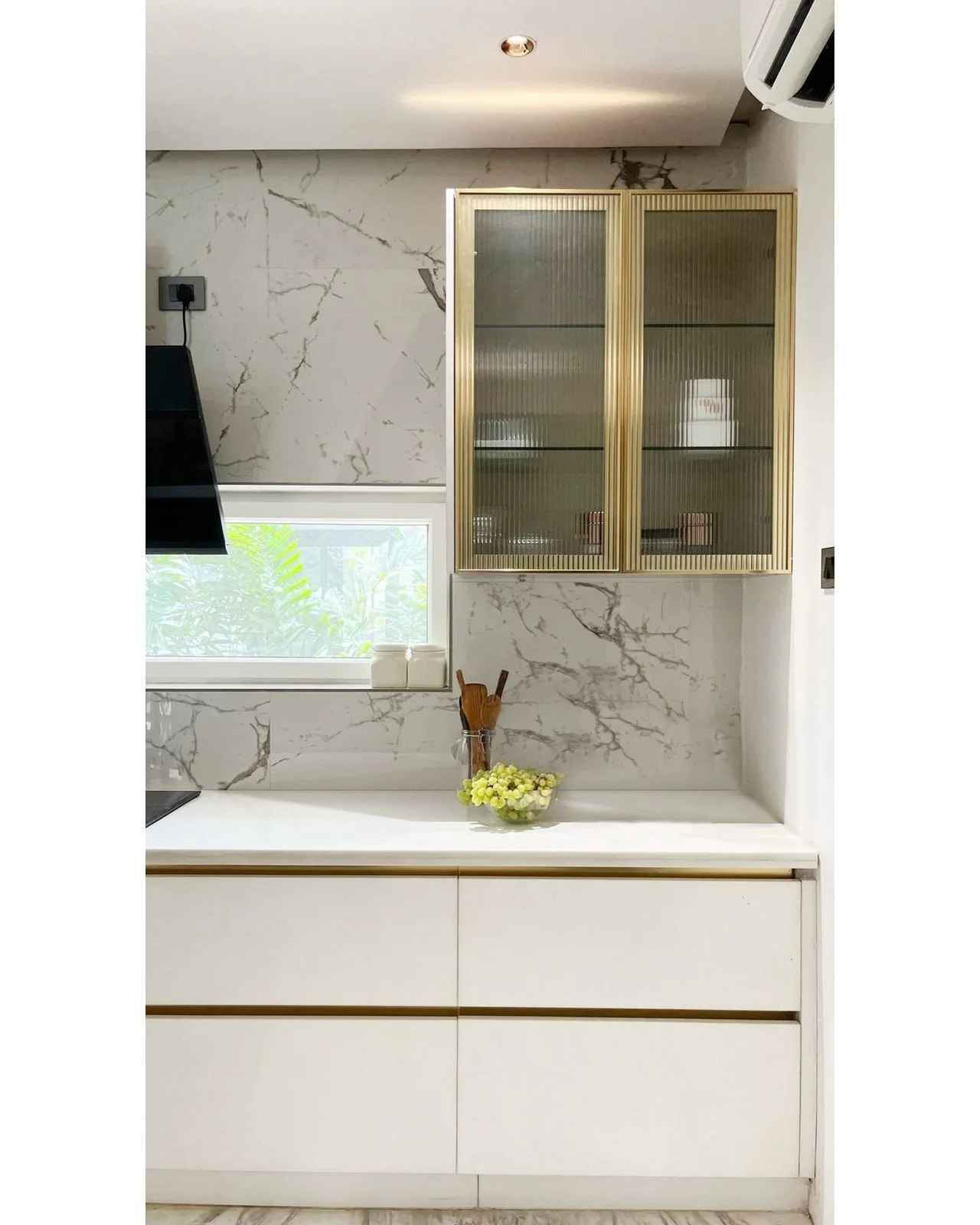 Kitchen with marble counter and brass-framed display cabinet