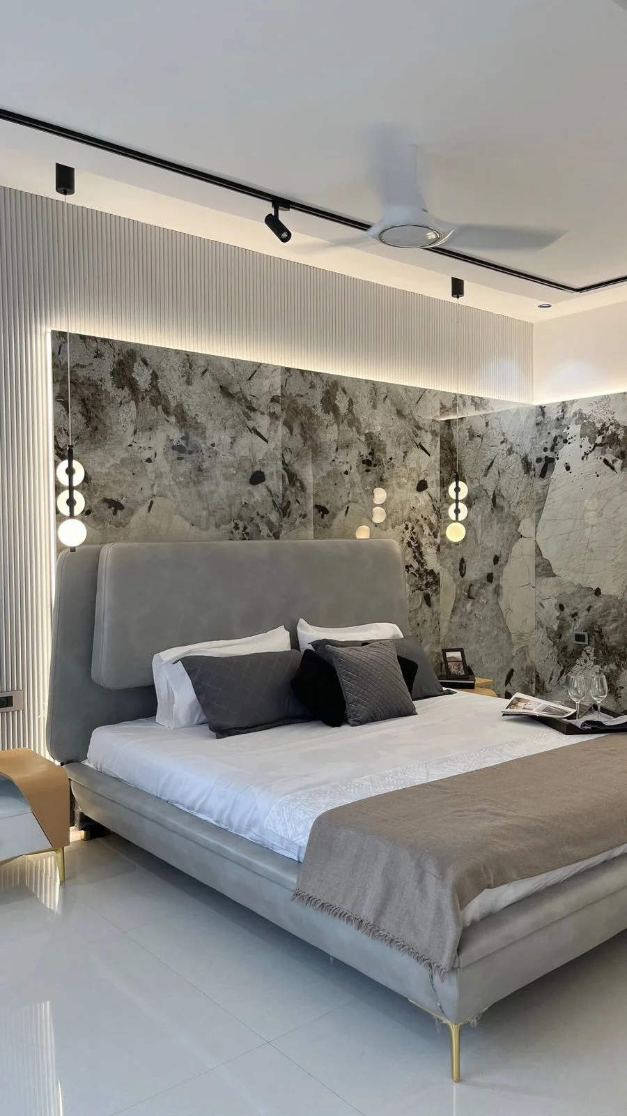 Bedroom with marble headboard panel and track lighting