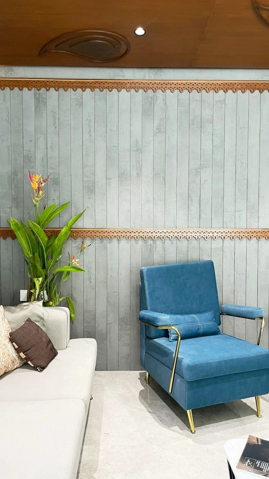 An'teak Villa, Hyderabad — sitting area with textured grey wall panelling edged in carved timber trim