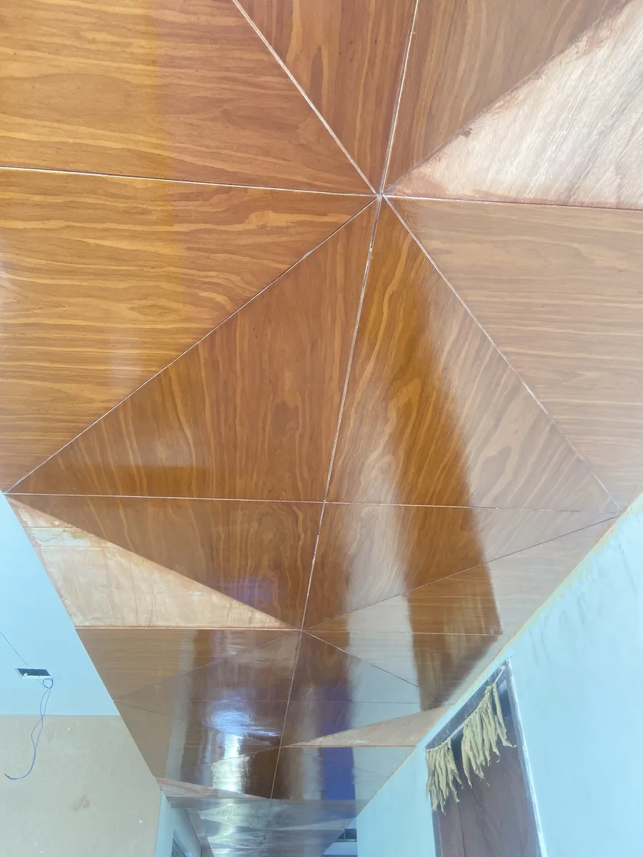 Villa interior in Hyderabad by AlcorOne Solutions — Book-matched veneer ceiling