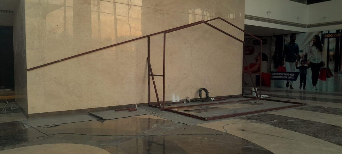 Welded steel frame standing against the kiosk back wall