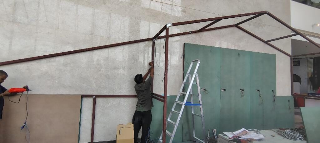 Worker fixing board panels to the erected steel frame